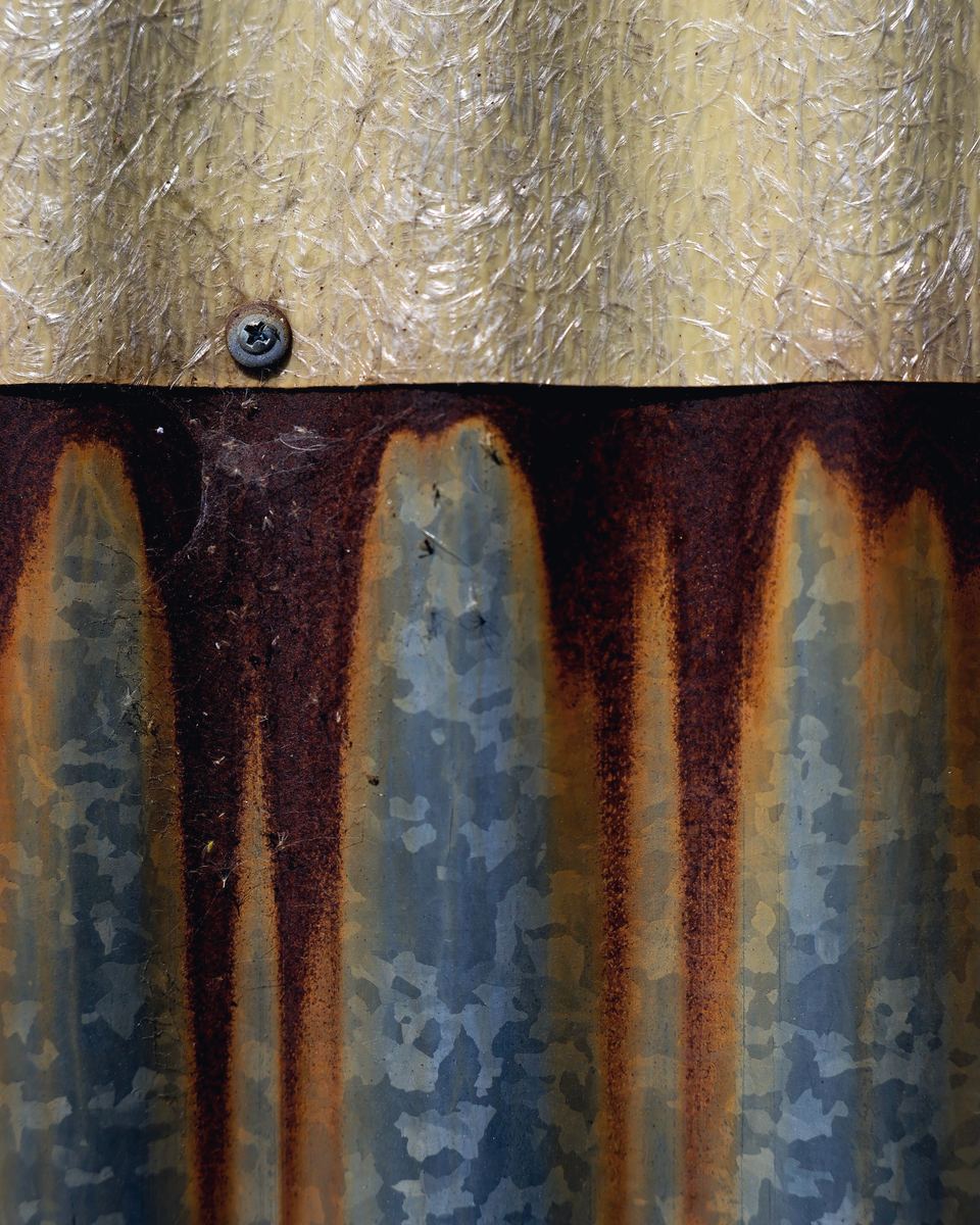 Rust running down from where one roof sheet overlaps another, on galvanised steel.