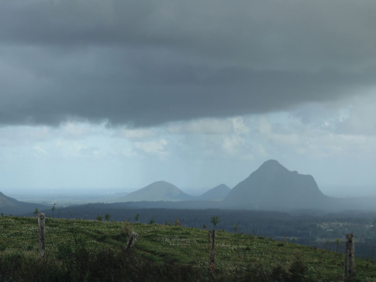Dark storm cloud and rain over the Glass House Mountains in the Sunshine Coast hinterland.