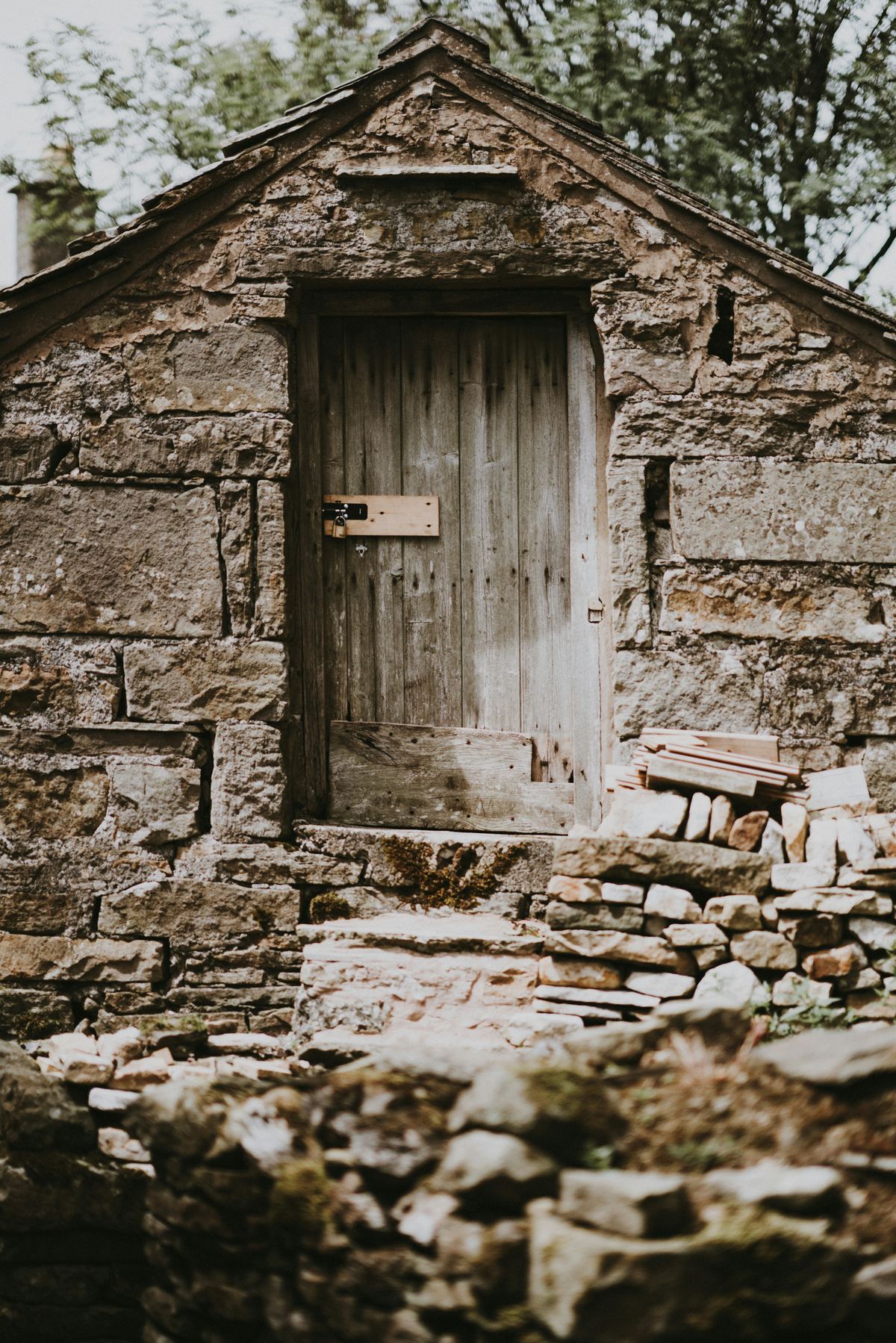 The old stone stable with its weathered timber door.