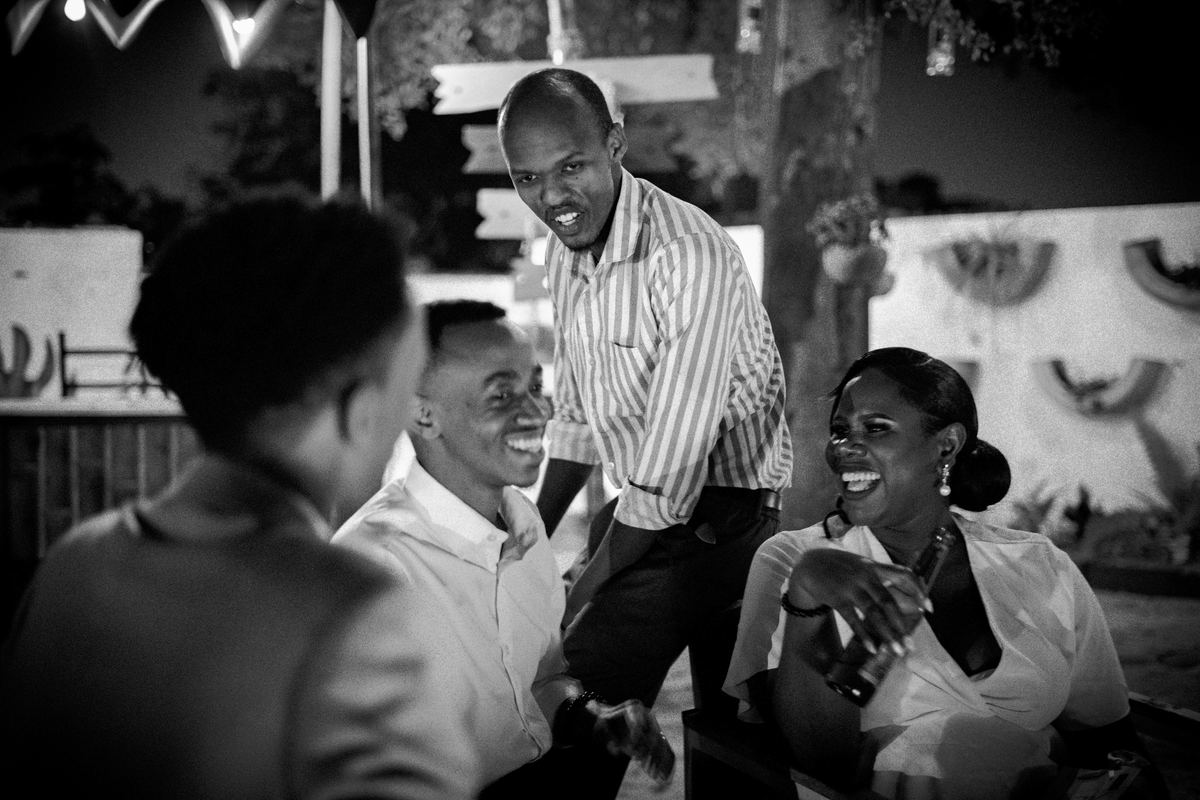 Guests laughing together at the bar, in black and white.